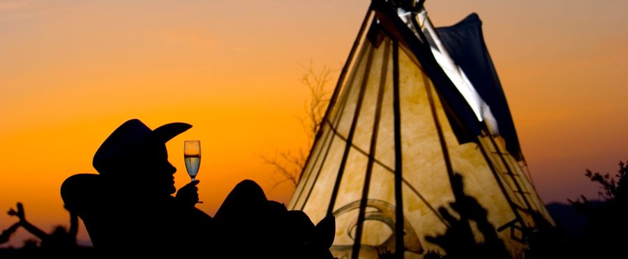 Cowboy silhouette at sunset in front of a tipi at Grand Canyon Western Ranch