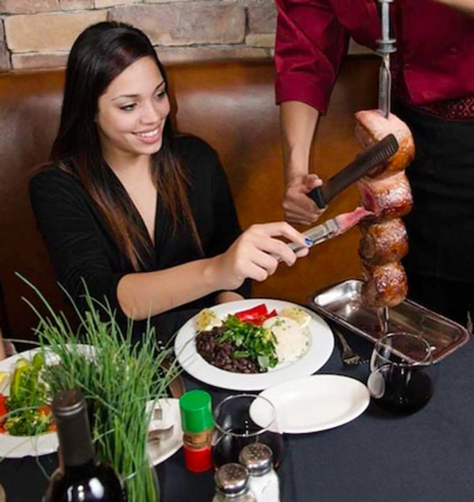 Server carving rodizio meat at the table at Pampas Brazilian Steakhouse